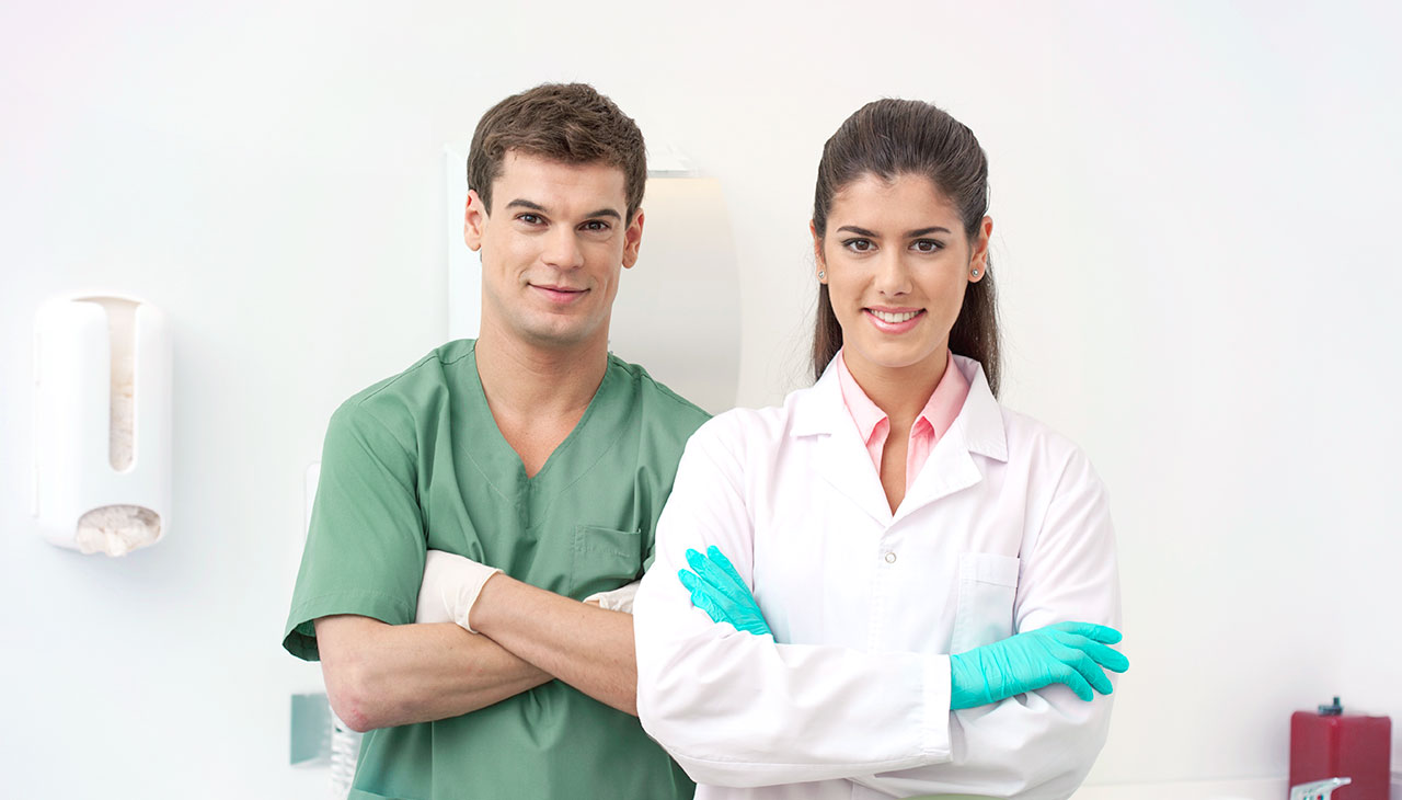 Dua dokter gigi berdiri di klinik gigi dan menunggu pasien berikutnya.