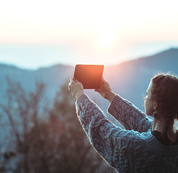 Mujer tomando una foto de las montañas