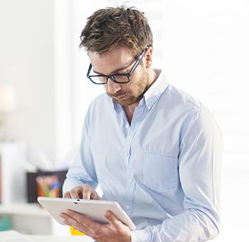 Professionel revisor tjekker sit kommende skema på Planfy -kalenderen ved hjælp af sin tablet.