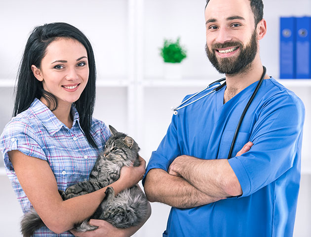 Veterinário e dono de um animal de estimação posando após uma consulta no veterinário.